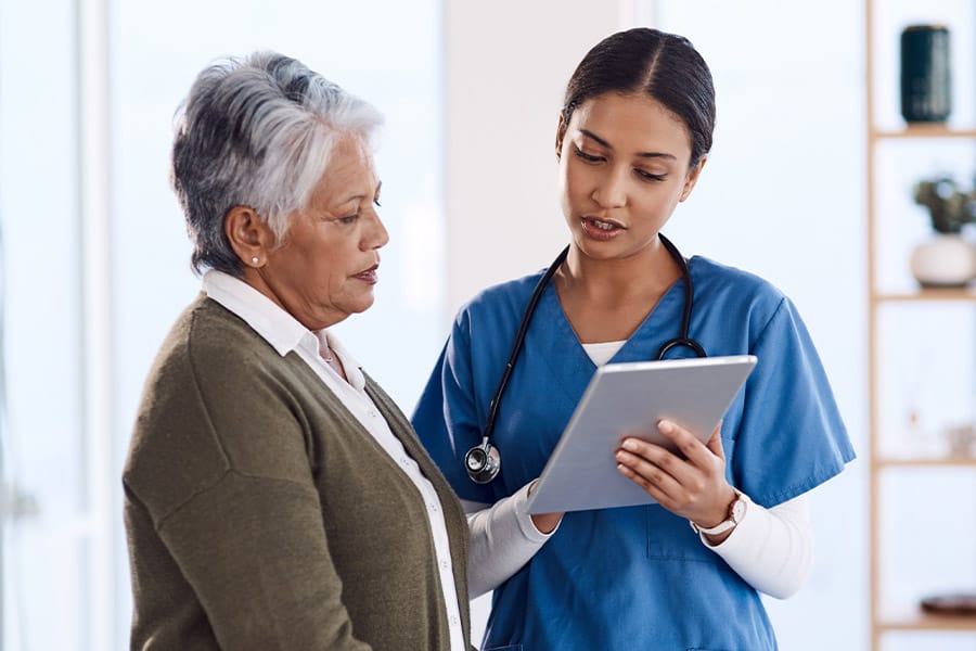 nurse discussing chart with elderly patient