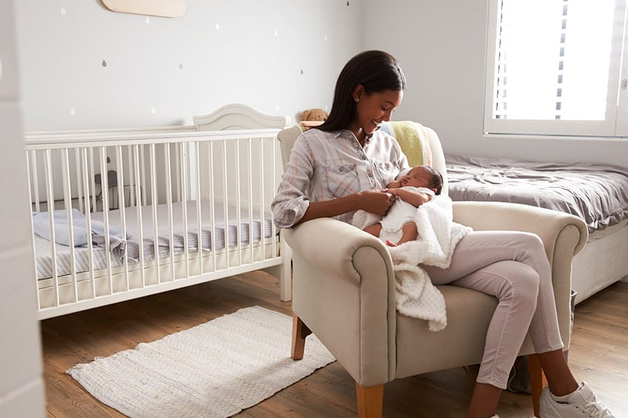 mother rocking baby in nursery